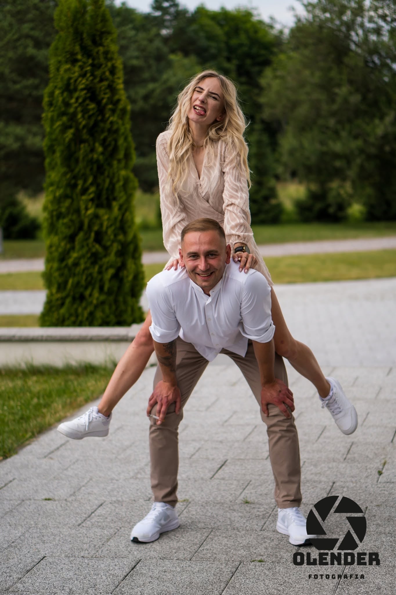 Para w parku: ona na barana u niego, oboje się śmieją